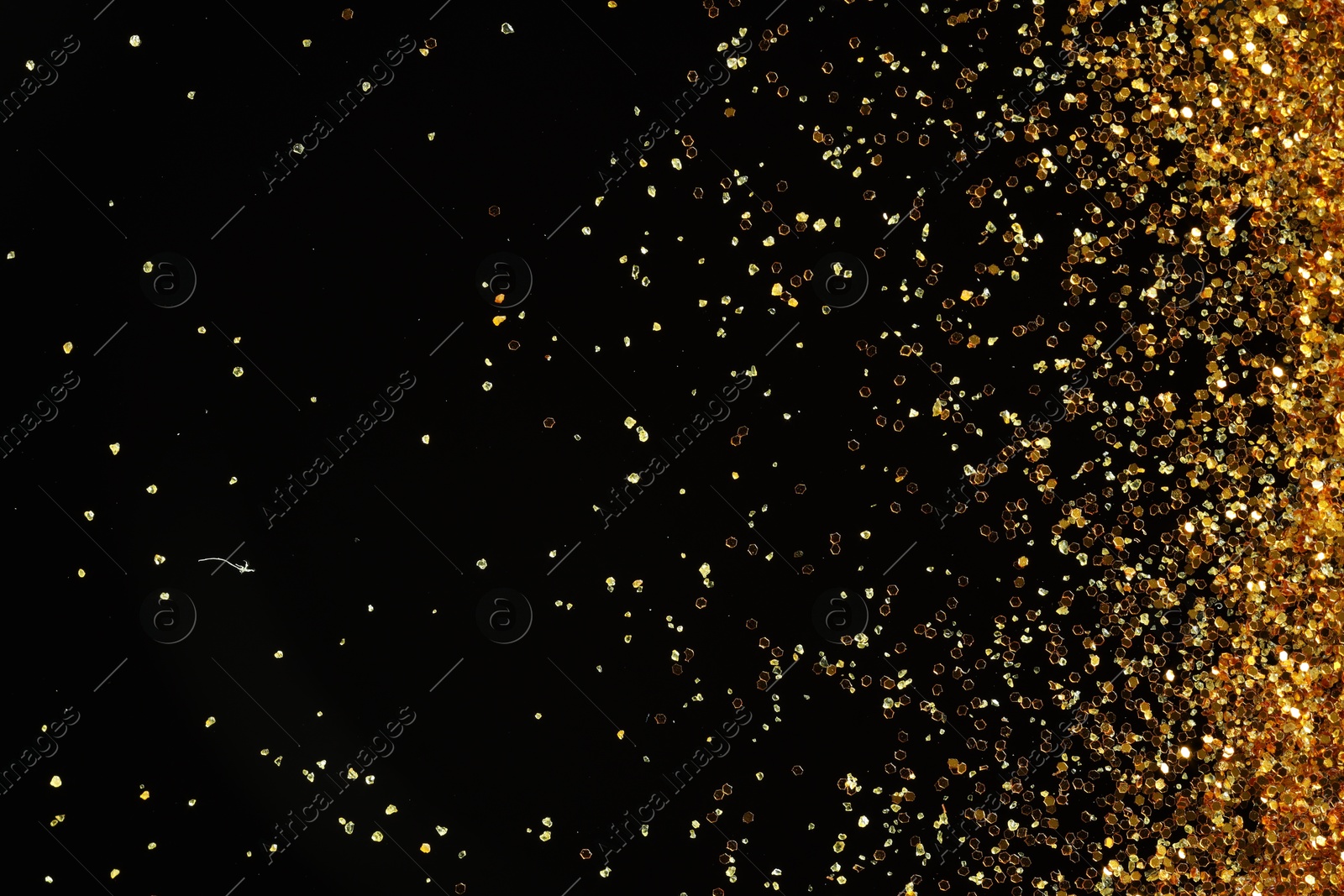 Photo of Beautiful shiny golden glitter on black background, top view