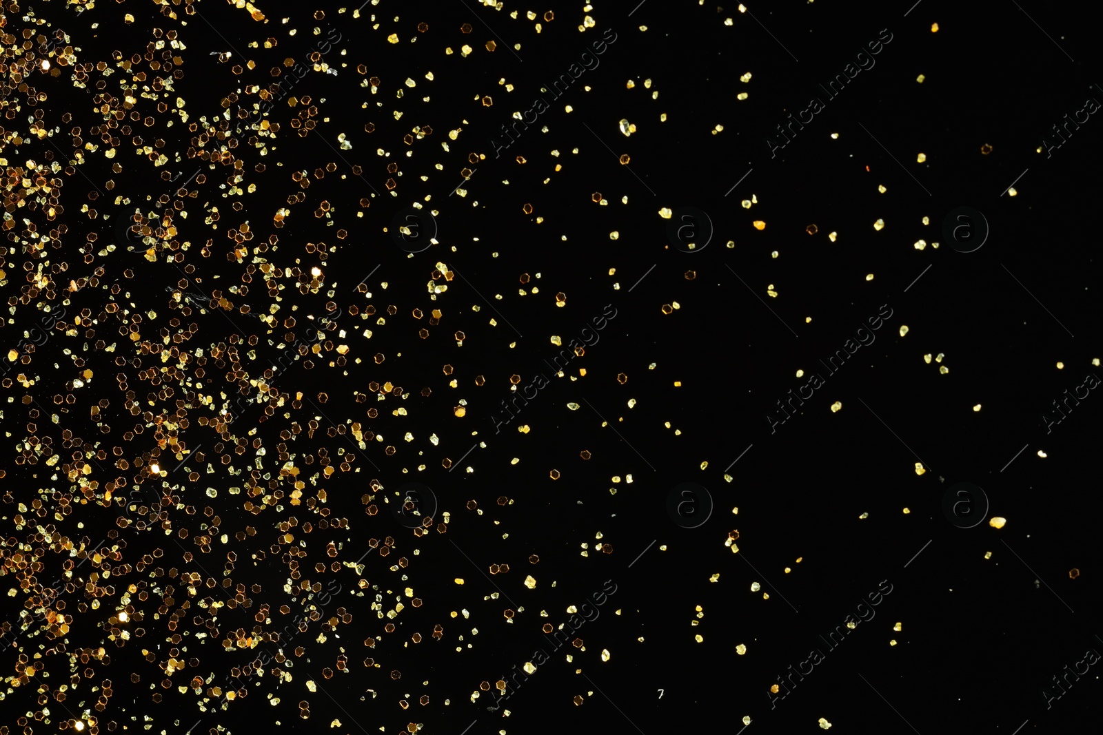 Photo of Beautiful shiny golden glitter on black background, top view