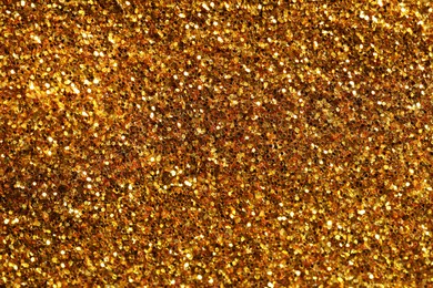 Photo of Beautiful shiny golden glitter as background, top view