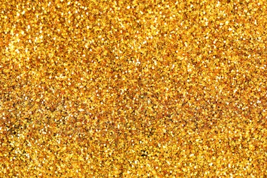 Photo of Beautiful shiny golden glitter as background, top view