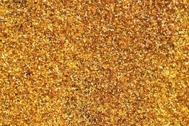 Photo of Beautiful shiny golden glitter as background, top view