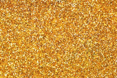 Photo of Beautiful shiny golden glitter as background, top view