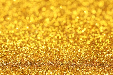 Photo of Beautiful shiny golden glitter as background, closeup