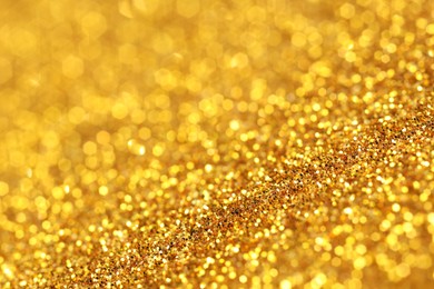 Photo of Beautiful shiny golden glitter as background, closeup