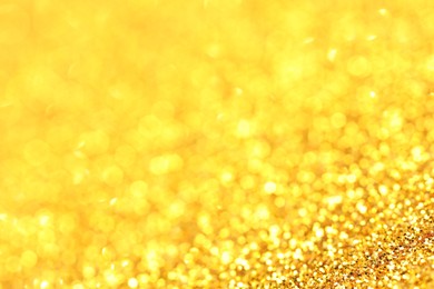 Photo of Beautiful shiny golden glitter as background, closeup