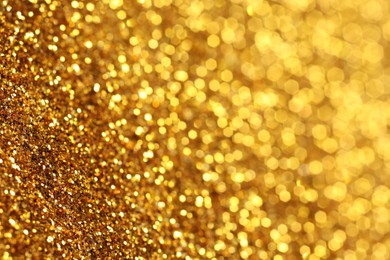 Photo of Beautiful shiny golden glitter as background, closeup