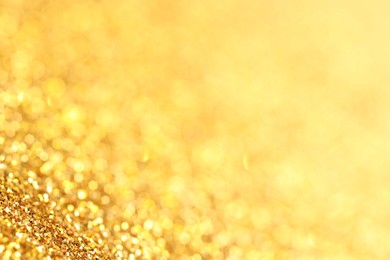 Photo of Beautiful shiny golden glitter as background, closeup