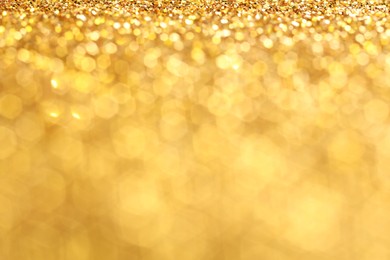 Photo of Beautiful shiny golden glitter as background, closeup