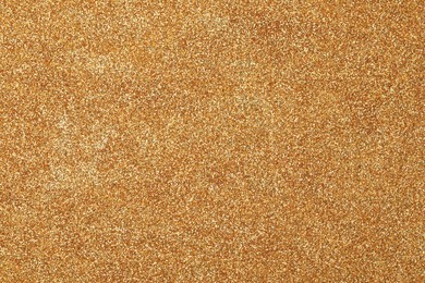 Photo of Beautiful shiny golden glitter as background, top view