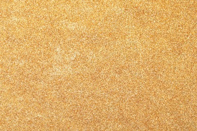 Photo of Beautiful shiny golden glitter as background, top view