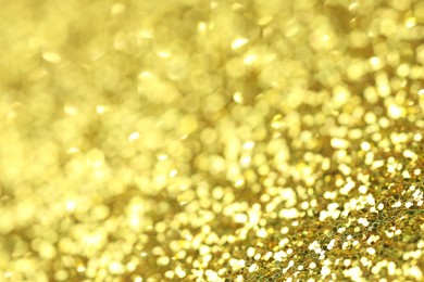 Photo of Beautiful shiny golden glitter as background, closeup