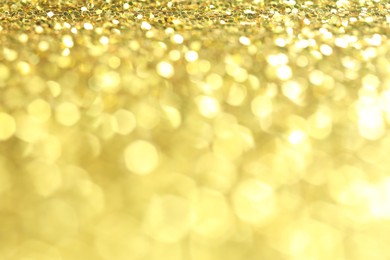 Photo of Beautiful shiny golden glitter as background, closeup