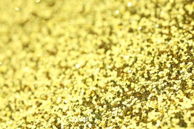 Photo of Beautiful shiny golden glitter as background, closeup