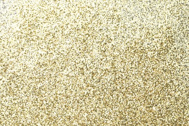 Photo of Beautiful shiny golden glitter as background, top view