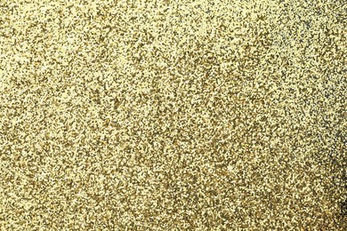 Photo of Beautiful shiny golden glitter as background, top view