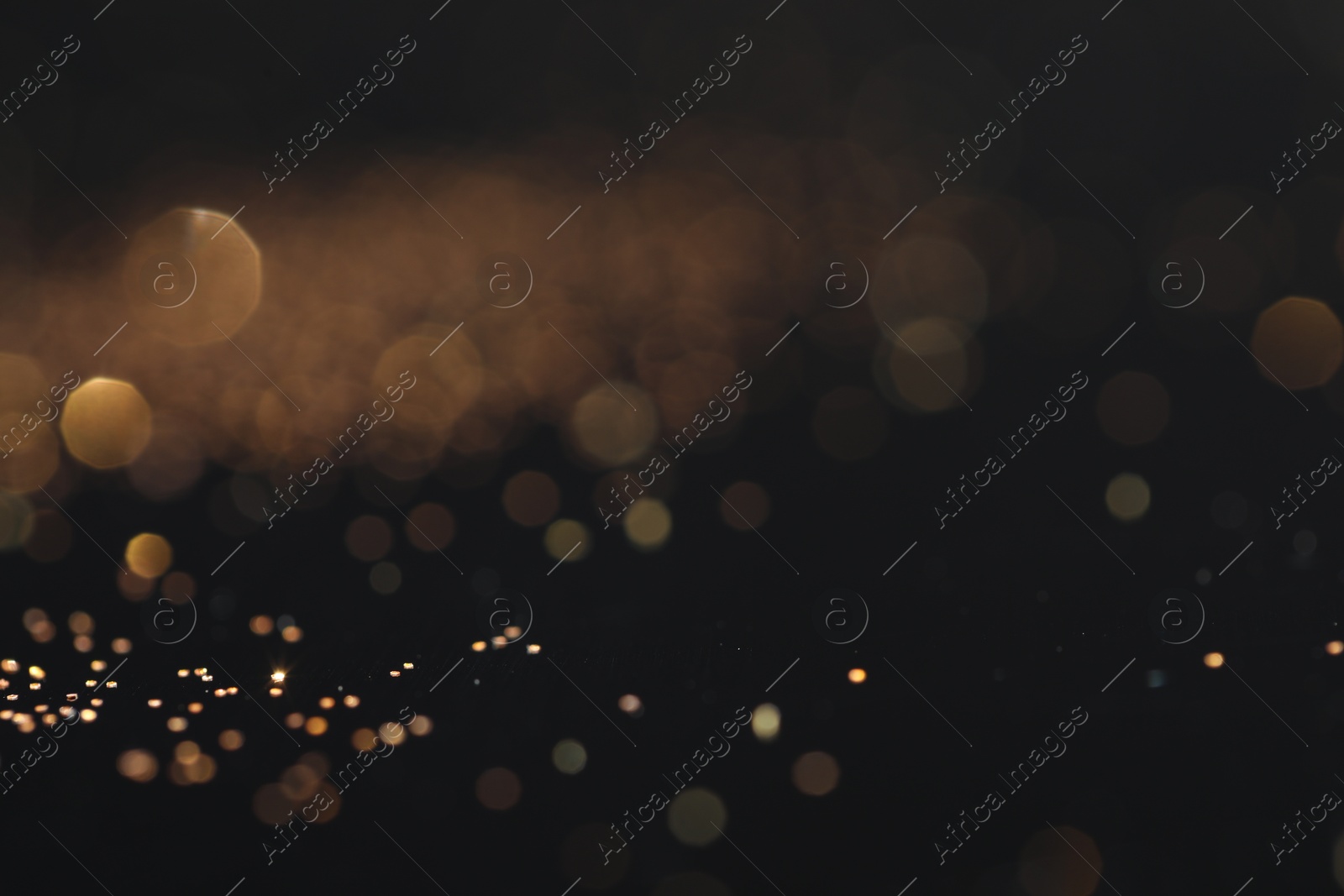 Photo of Beautiful shiny golden glitter on black background, closeup