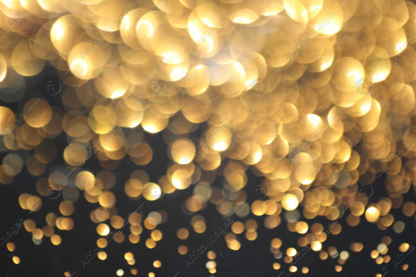 Photo of Beautiful shiny golden glitter on black background, closeup