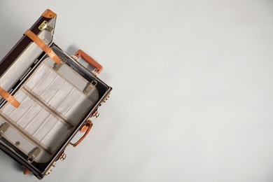 Photo of Open empty suitcase on light grey background, top view. Space for text