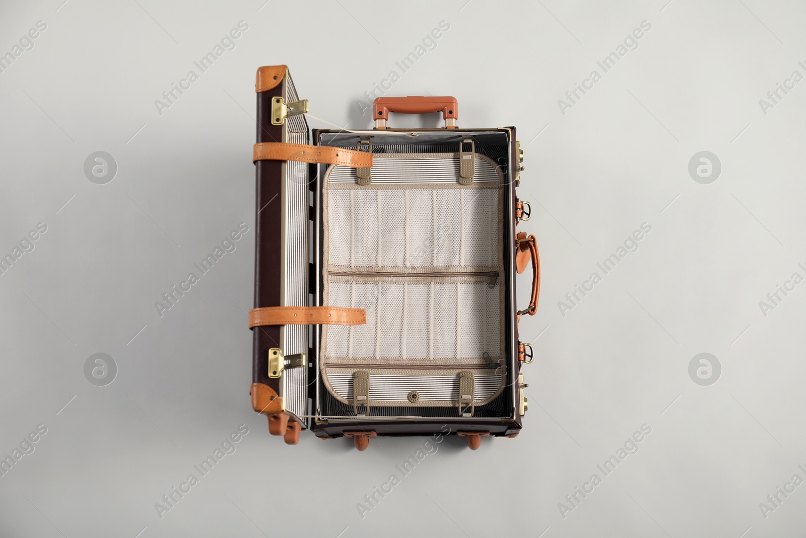 Photo of Open empty suitcase on light grey background, top view. Space for text