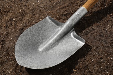 Photo of Metal shovel on pile of soil, closeup