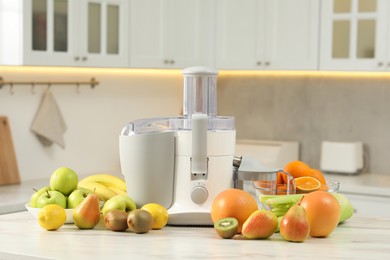 Photo of Modern juicer and fruits on white marble table in kitchen