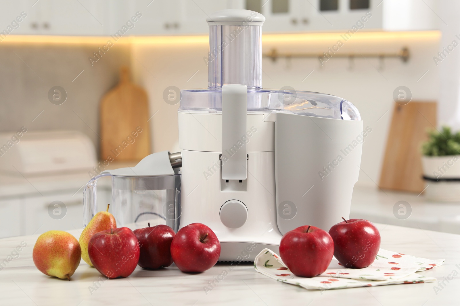 Photo of Modern juicer, pears and apples on white marble table in kitchen