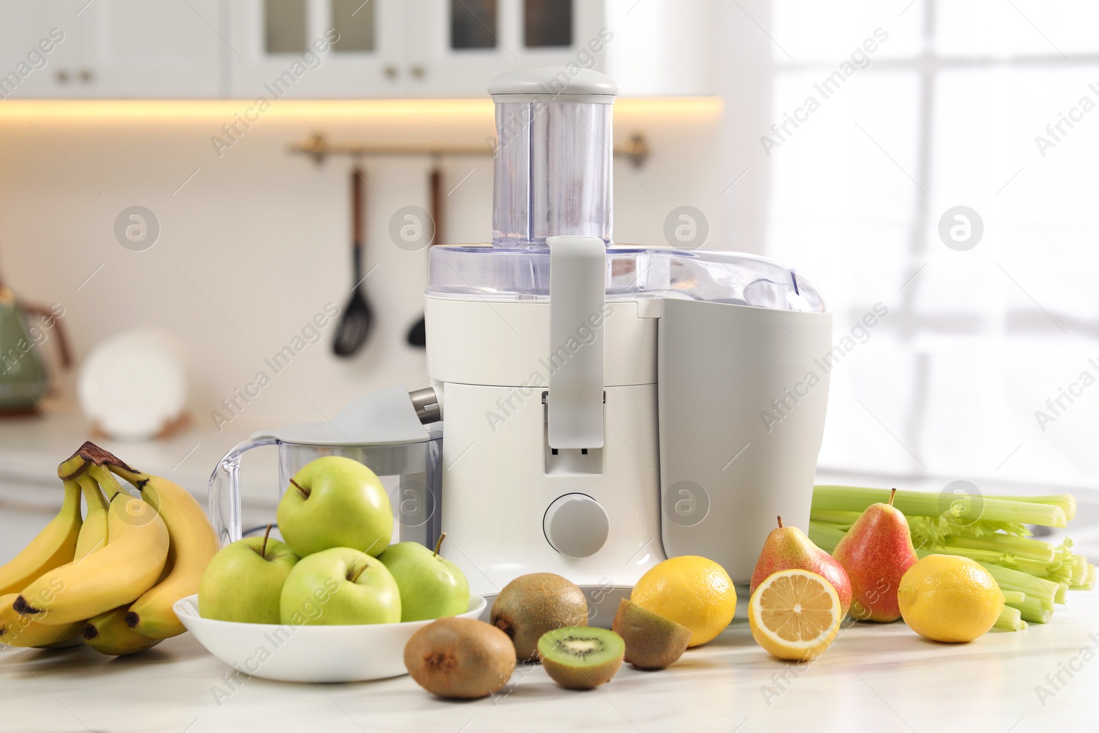 Photo of Modern juicer and fruits on white marble table in kitchen