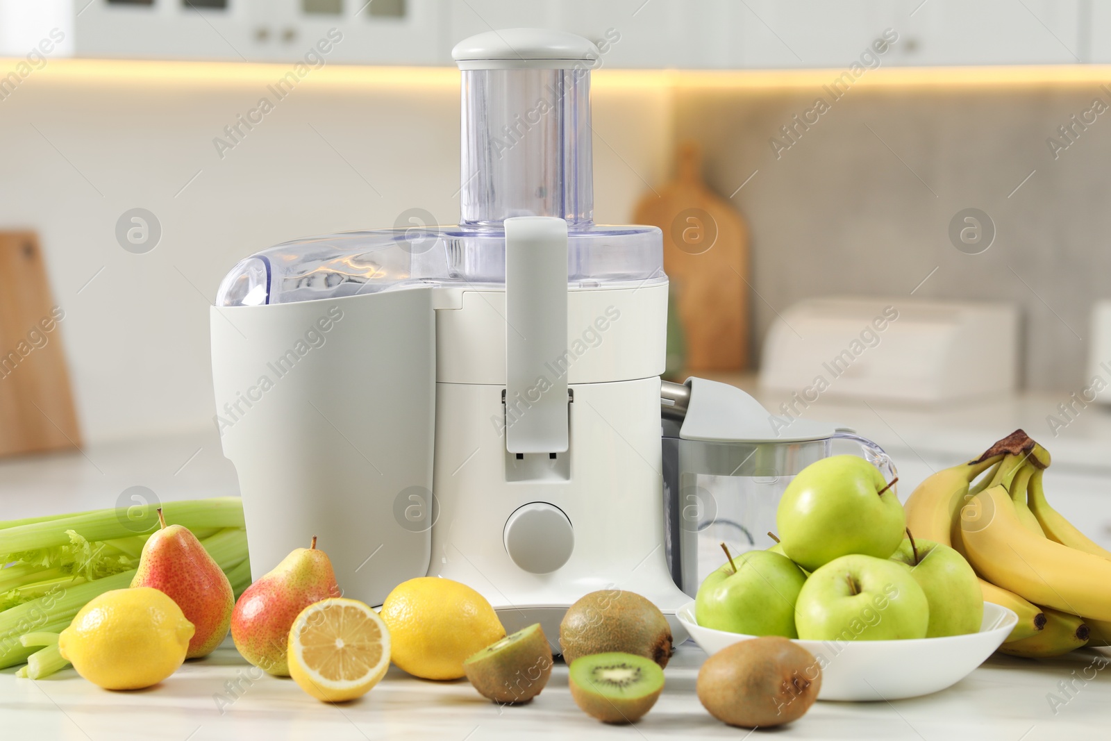 Photo of Modern juicer and fruits on white marble table in kitchen