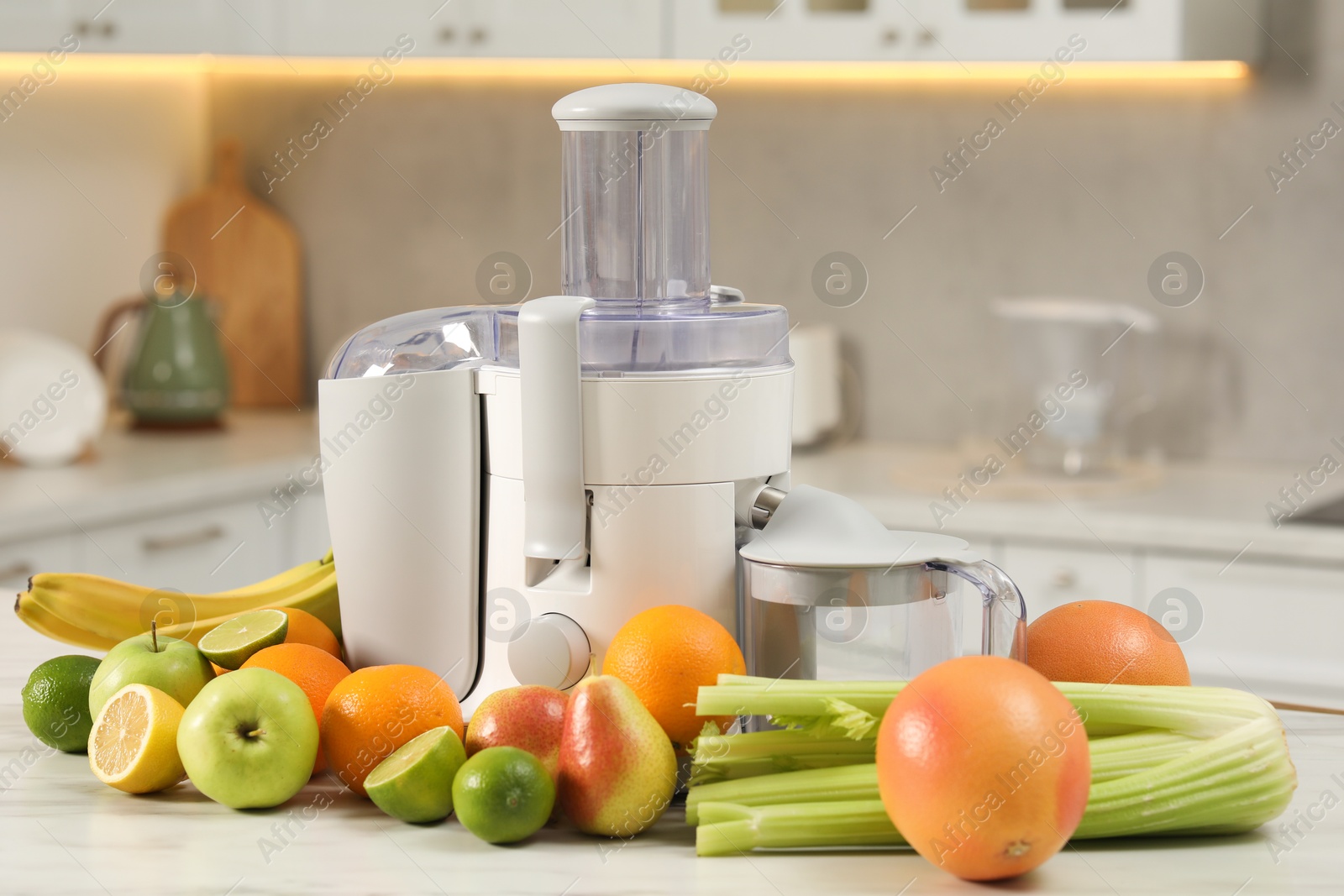 Photo of Modern juicer and fruits on white marble table