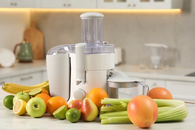 Modern juicer and fruits on white marble table