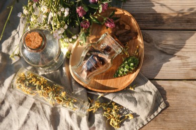 Tincture and different ingredients on wooden table, top view