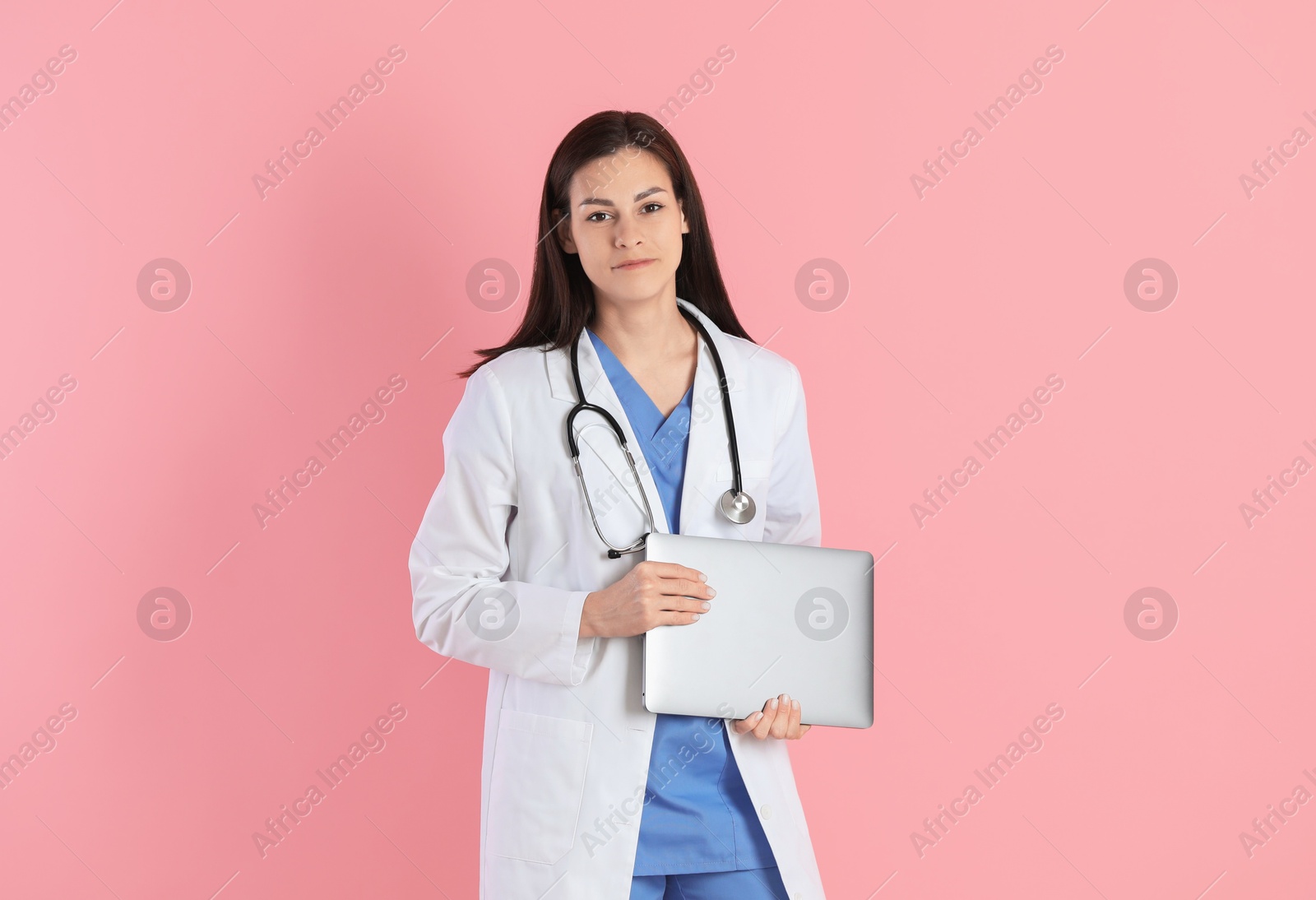 Photo of Beautiful nurse with laptop on pink background