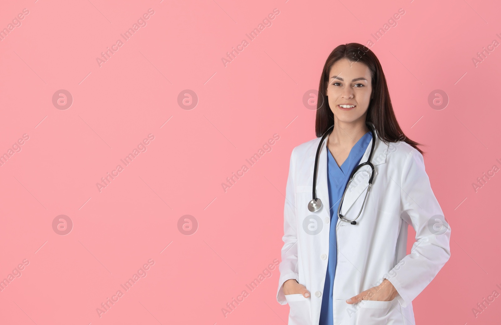 Photo of Smiling nurse with stethoscope on pink background. Space for text