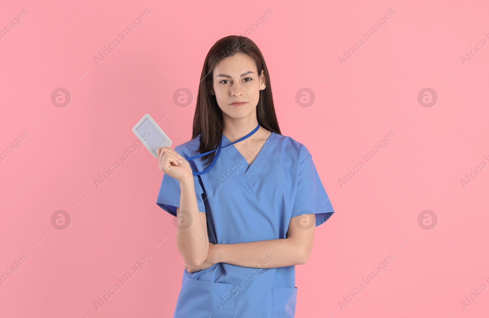 Photo of Beautiful nurse with badge on pink background