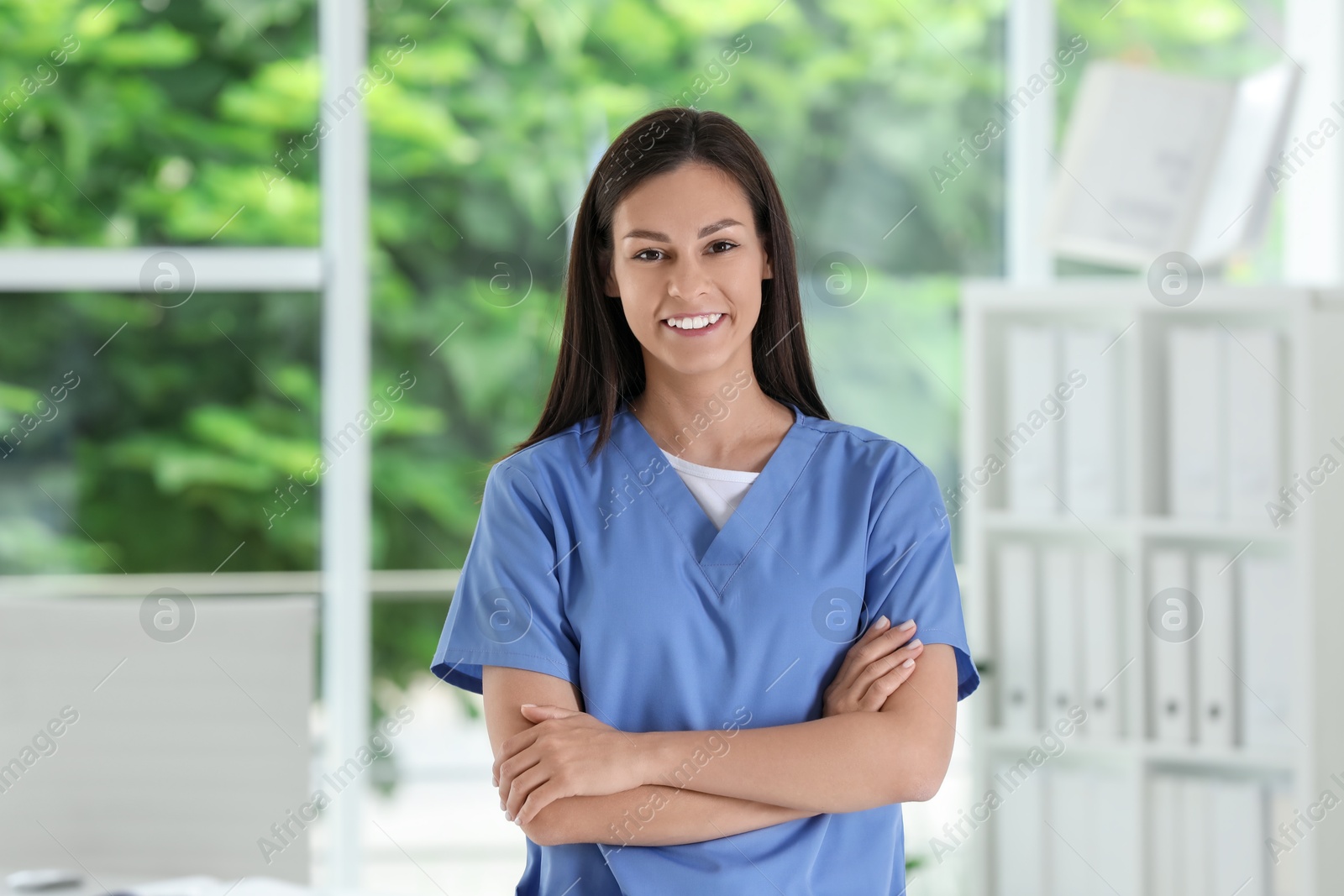 Photo of Smiling nurse with crossed arms in hospital office