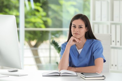 Photo of Portrait of beautiful nurse at table in hospital office