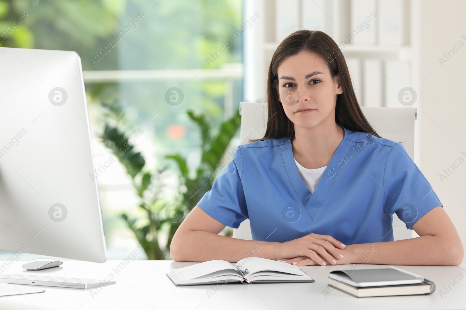 Photo of Portrait of beautiful nurse at table in hospital office