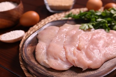 Making schnitzel. Board with raw meat on wooden table, closeup