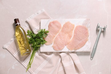 Making schnitzel. Raw meat chops, parsley, oil and tenderizer on light marble table, flat lay