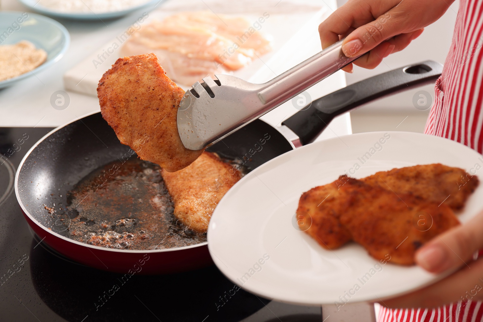 Photo of Woman cooking schnitzels in frying pan on stove, closeup