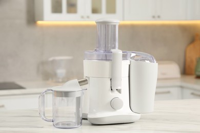 Modern juicer on white marble table in kitchen