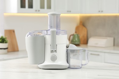 Modern juicer on white marble table in kitchen