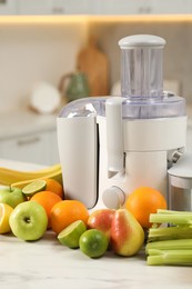 Modern juicer and fruits on white marble table