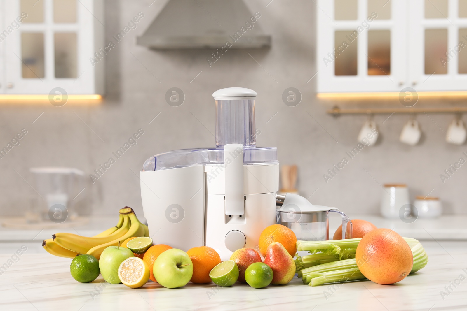 Photo of Modern juicer and fruits on white marble table