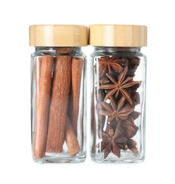 Cinnamon sticks and anise stars in glass jars isolated on white