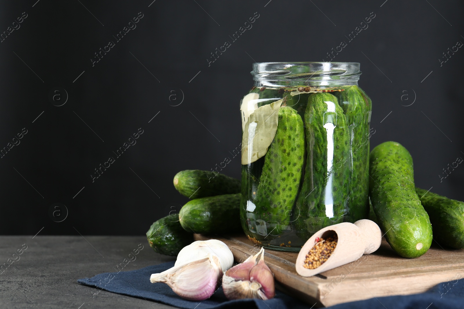 Photo of Making pickles. Fresh cucumbers and spices in jar on grey table. Space for text