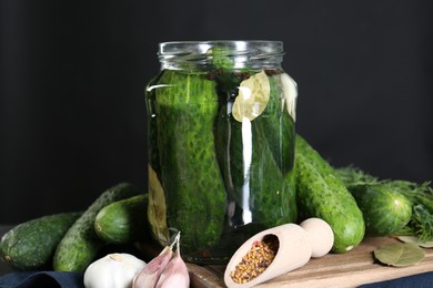 Photo of Making pickles. Fresh cucumbers and spices in jar on table, closeup