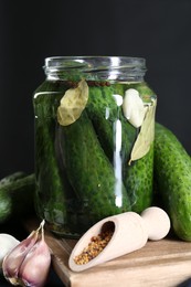 Photo of Making pickles. Fresh cucumbers and spices in jar on table, closeup