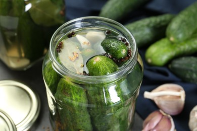 Photo of Making pickles. Fresh cucumbers and spices in jar on table, closeup