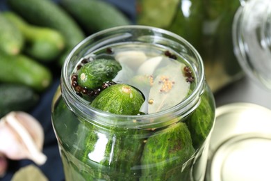 Photo of Making pickles. Fresh cucumbers and spices in jar, closeup